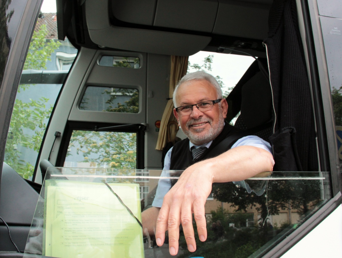 Smilende chauffør byder velkommen på en af vores 4* busser.